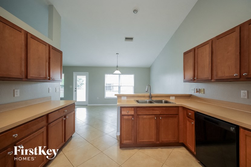 an empty kitchen with wooden cabinets and a sink