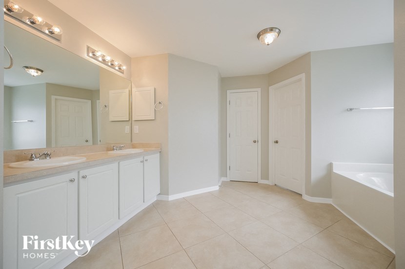 a bathroom with two sinks and a tub and a mirror