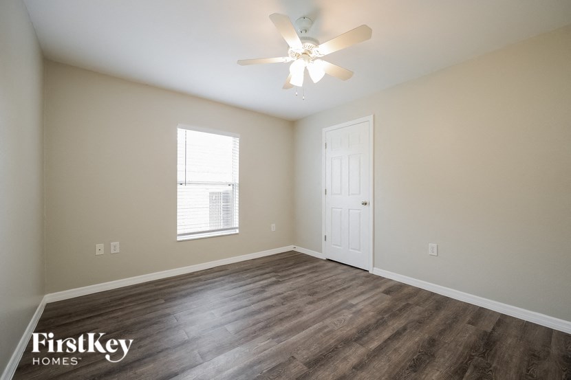 an empty room with a ceiling fan and a window