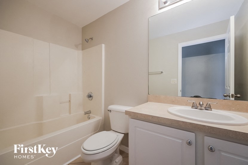 a bathroom with a sink toilet and a mirror
