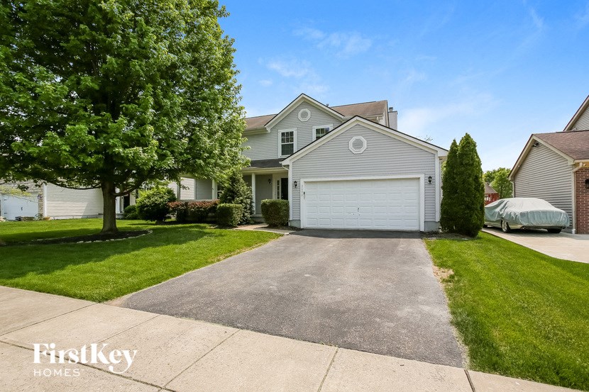 a blue house with a white garage door on a driveway