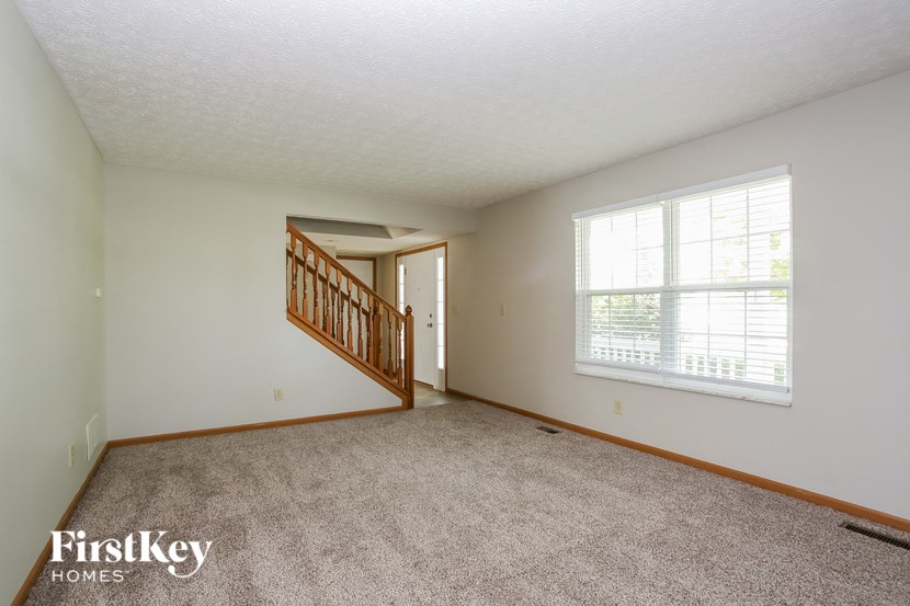 the living room and dining room of a house with a large window