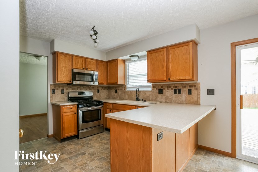 a kitchen with wooden cabinets and a white counter top