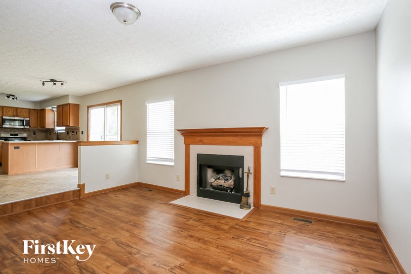 a living room with a fireplace and a wooden floor