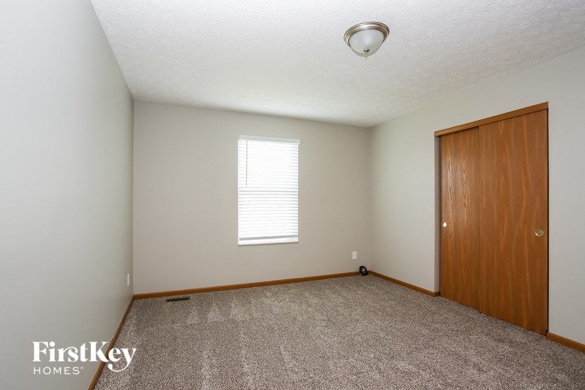 an empty room with a wooden door and a window