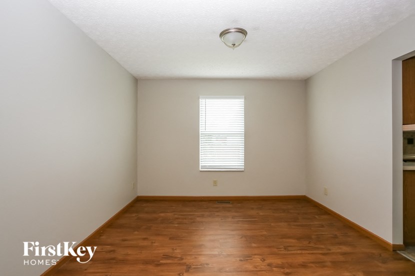 the living room of a home with wood floors and a window