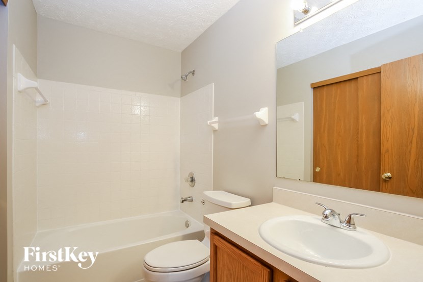 a bathroom with a sink toilet and a mirror