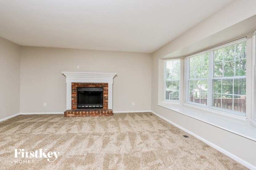 A room with a fireplace and a carpet.