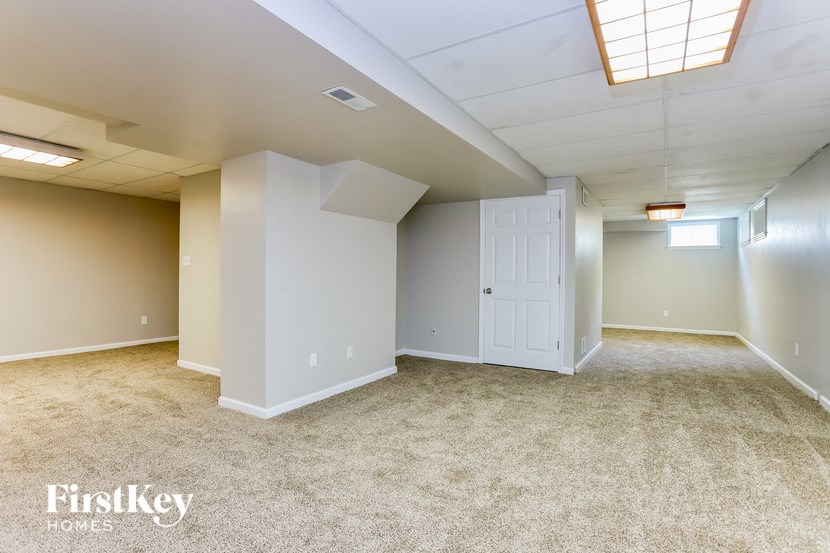 A spacious room with a carpeted floor and a skylight.