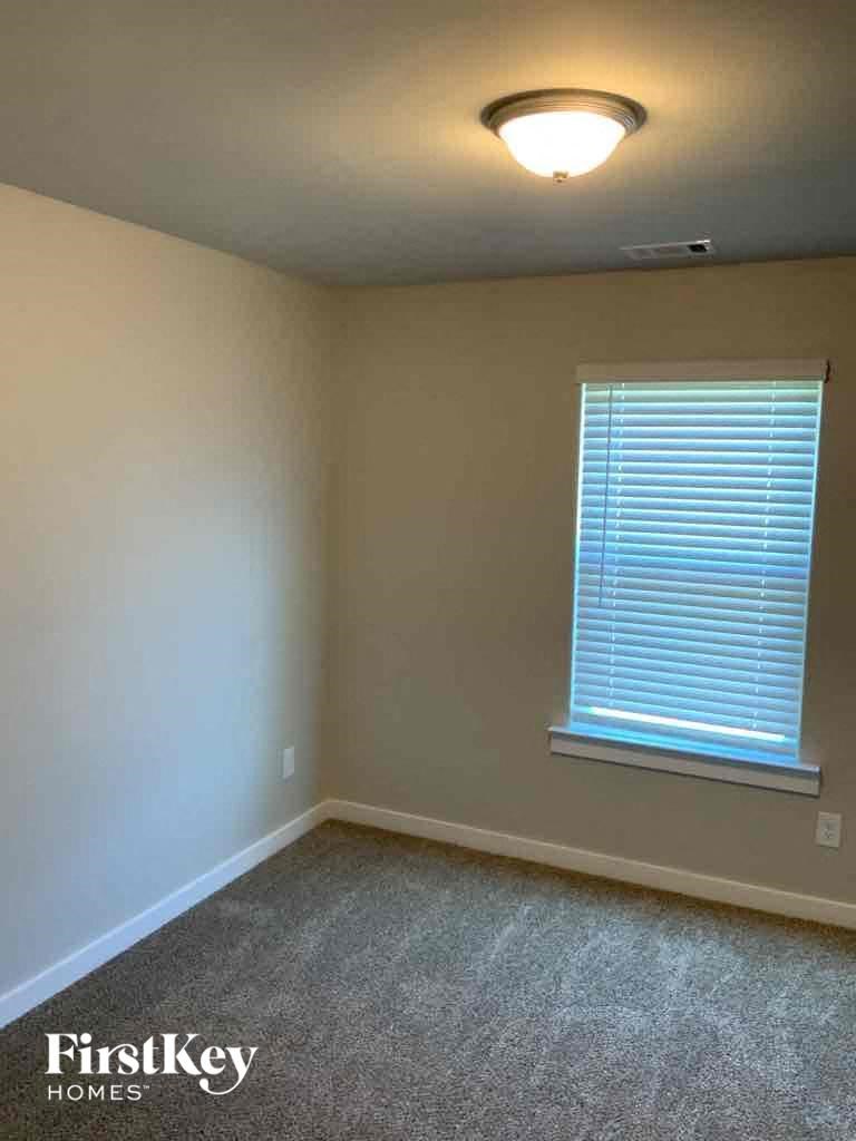 an empty room with a window and a lamp on the ceiling