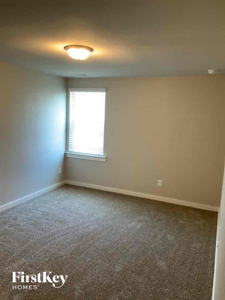 an empty room with a window and a lamp on the ceiling