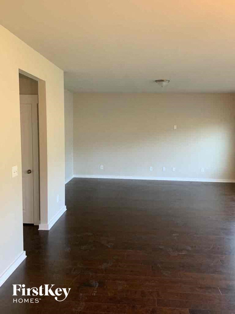 an empty living room with white walls and wood floors