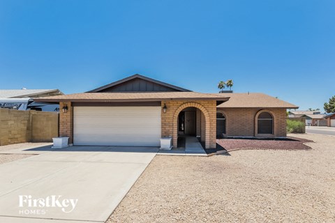 A house with a garage and a driveway in front of it.