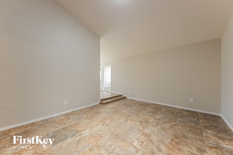 A spacious room with a stone floor and white walls.
