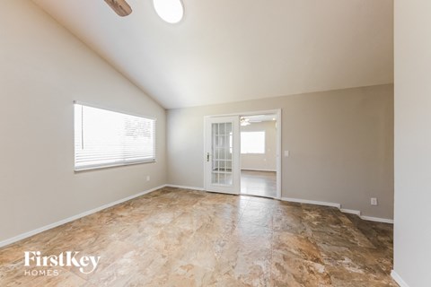 A room with a slanted ceiling and a doorway leading to another room.