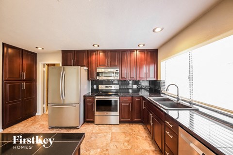 A kitchen with wooden cabinets and a refrigerator.