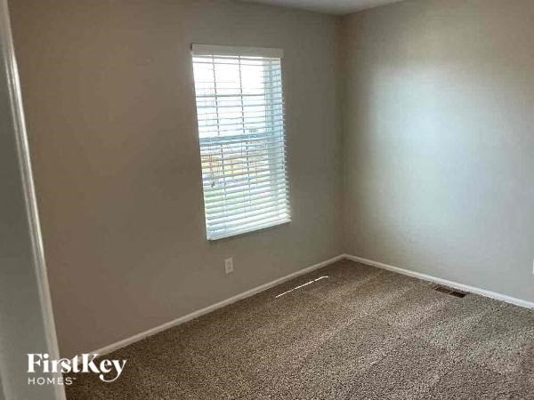 an empty room with a window and a carpet