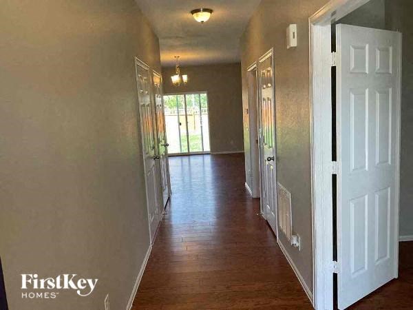 a hallway with a wood floor and a white door