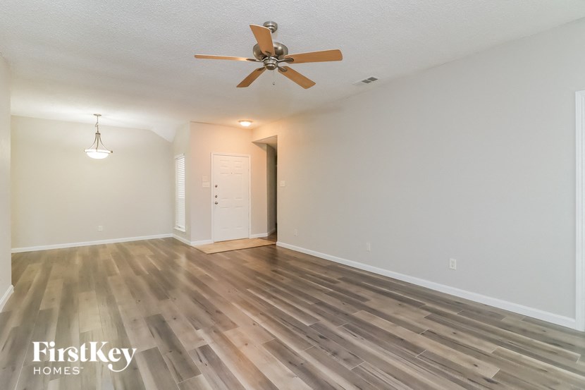 a living room with hardwood floors and a ceiling fan