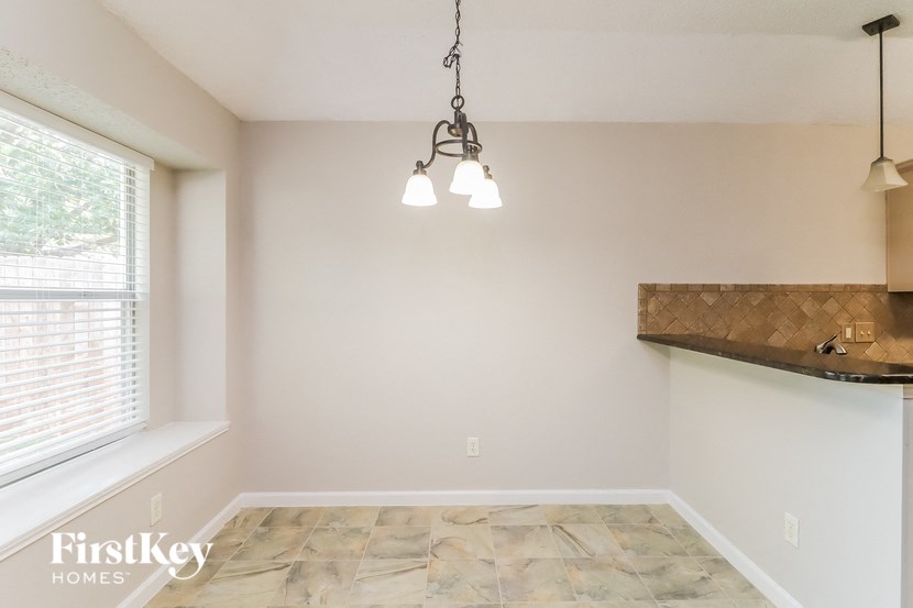 an empty living room with a window and a light fixture