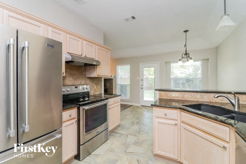 a large kitchen with stainless steel appliances and wooden cabinets
