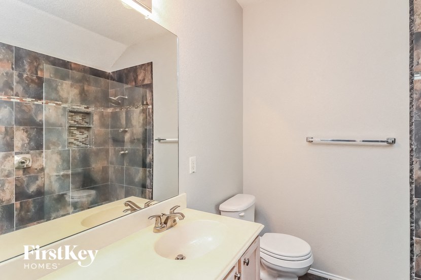 a bathroom with a toilet and a sink and a mirror