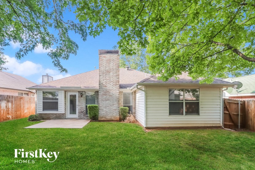 a small white house with a yard and a tree