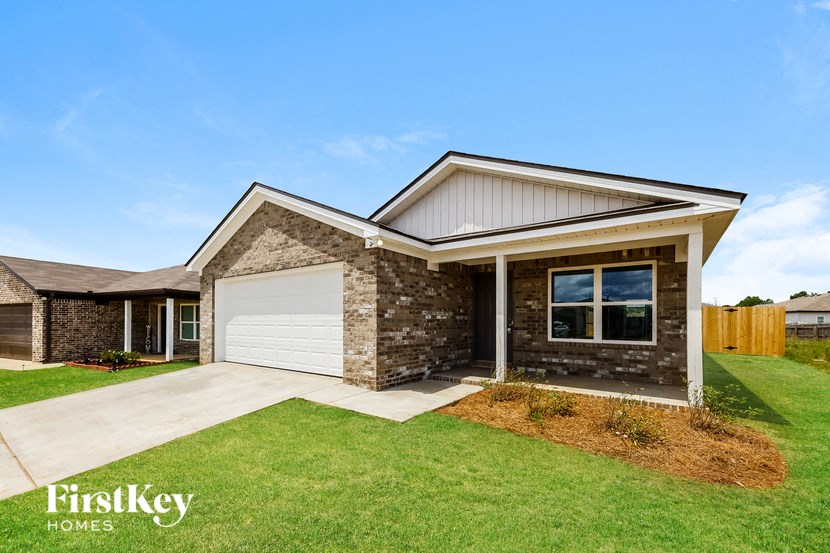 a home with a white garage door and a brick house