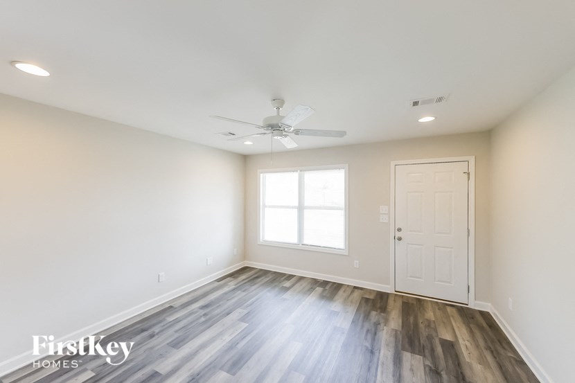 an empty room with a white door and a ceiling fan