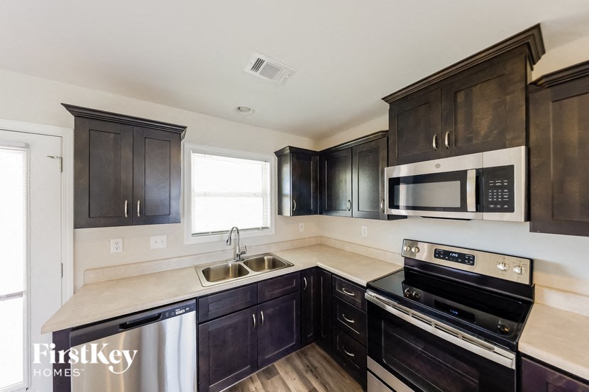 a kitchen with black cabinets and stainless steel appliances
