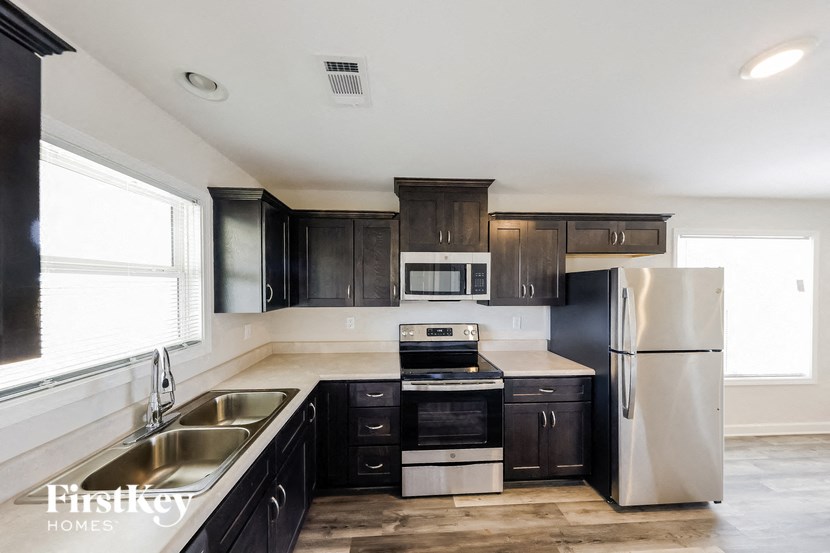a kitchen with black cabinets and stainless steel appliances