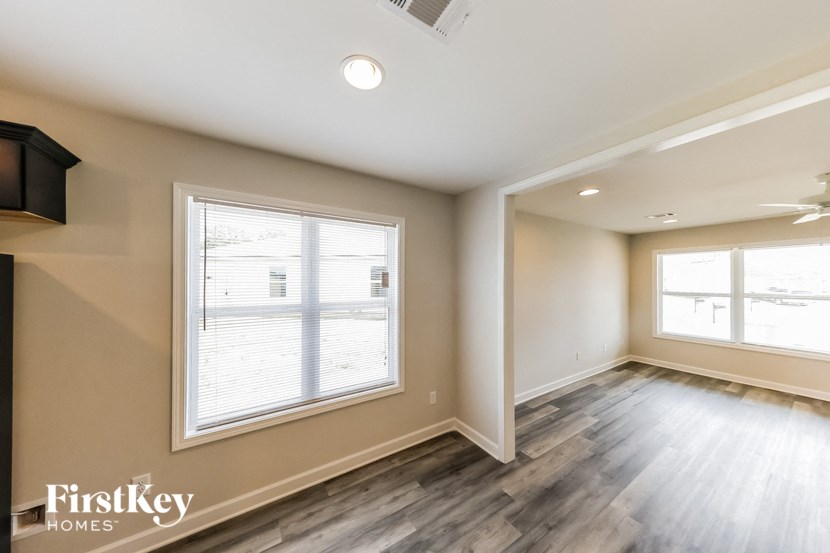 an empty living room with wood floors and a large window