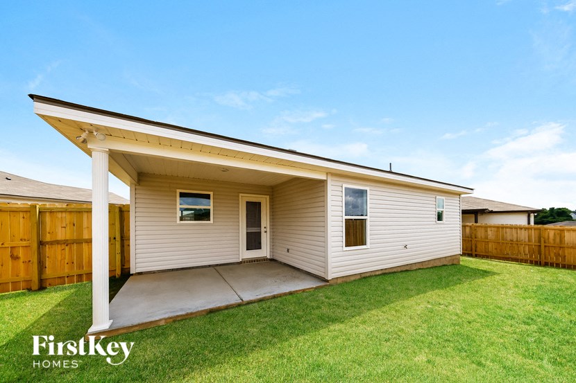 a small white house with a porch and a lawn