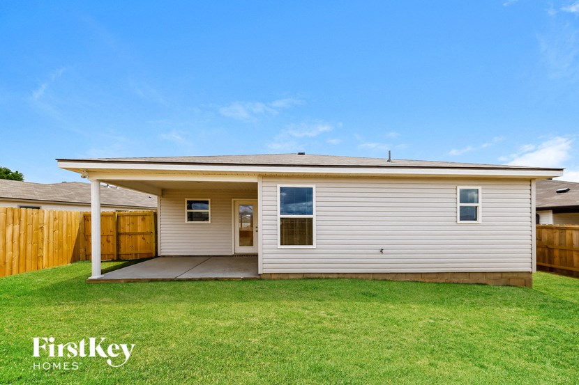 a small white house with a yard and a wooden fence