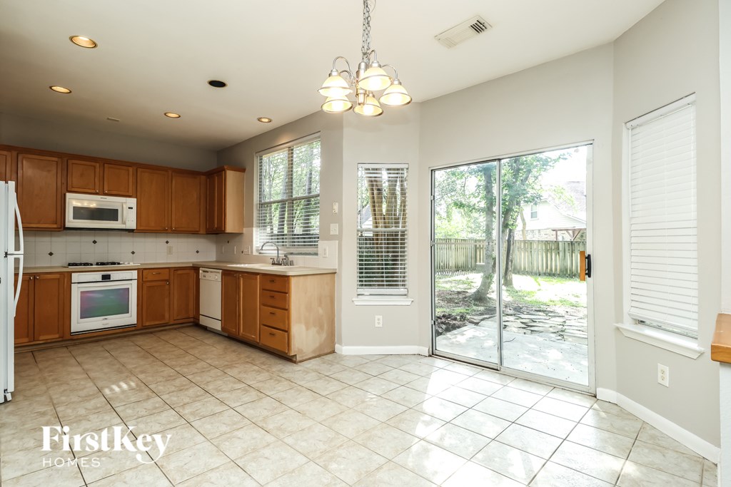 A kitchen with wooden cabinets and a tiled floor.
