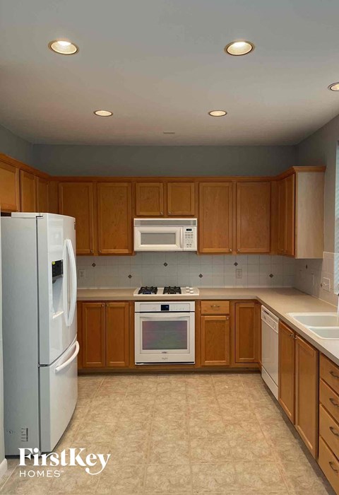 A kitchen with wooden cabinets and a white refrigerator.
