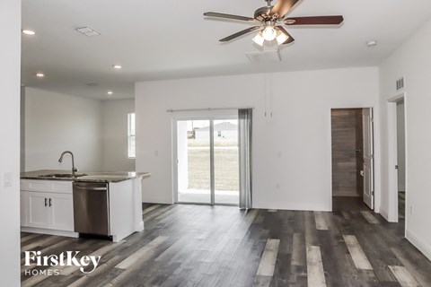 A spacious kitchen with a sink, stove, and a ceiling fan.