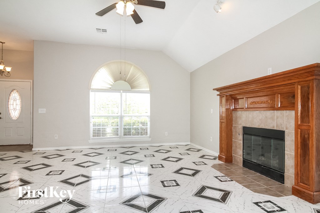 a living room with a fireplace and tiled floors
