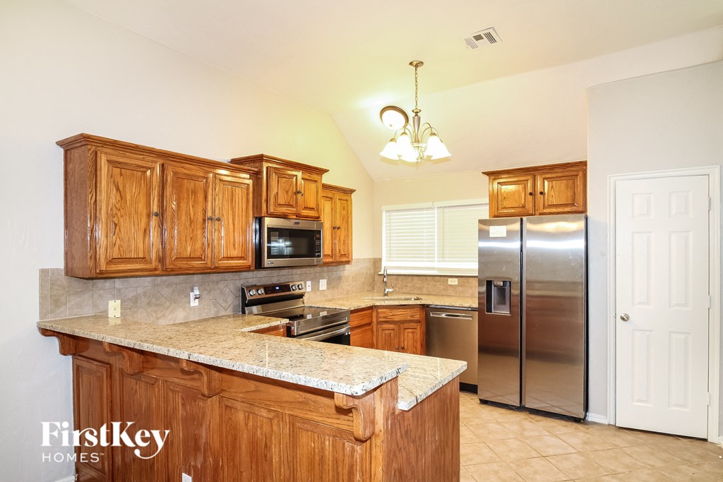 the kitchen is equipped with stainless steel appliances and granite counter tops