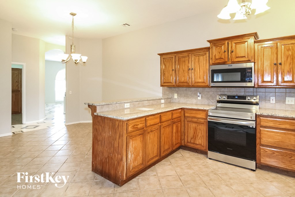 a kitchen with wooden cabinets and a stove and a sink
