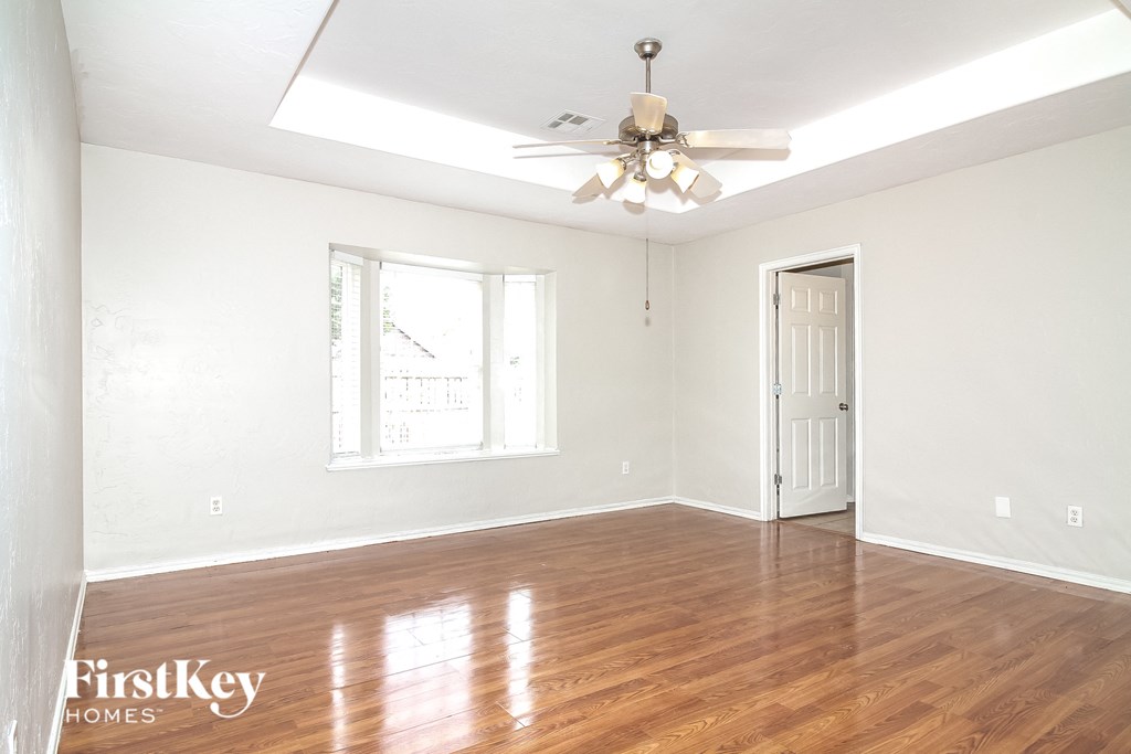 a living room with hardwood floors and a ceiling fan