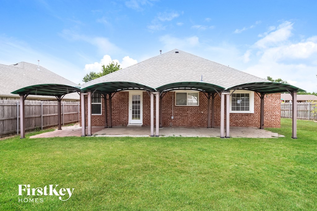 the backyard of a house with a yard and a patio with retractable roofs