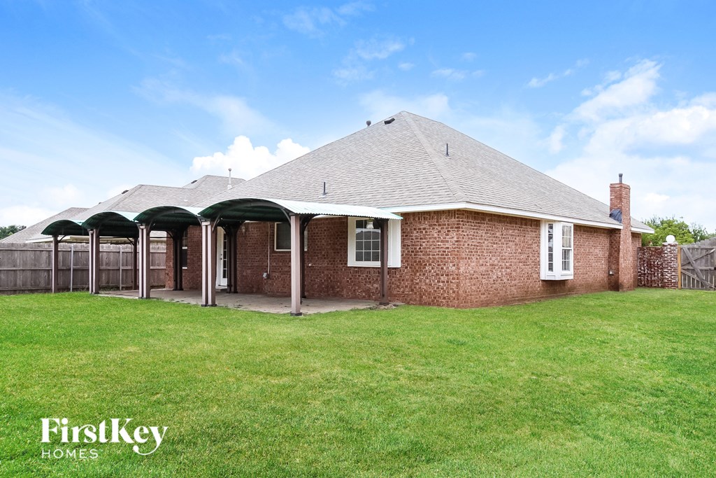 a backyard with a brick house and a green lawn