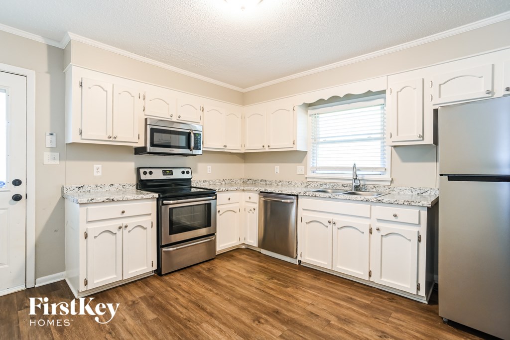 A kitchen with wooden cabinets and a stainless steel refrigerator.