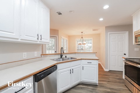 a kitchen with white cabinets and a sink and a dishwasher