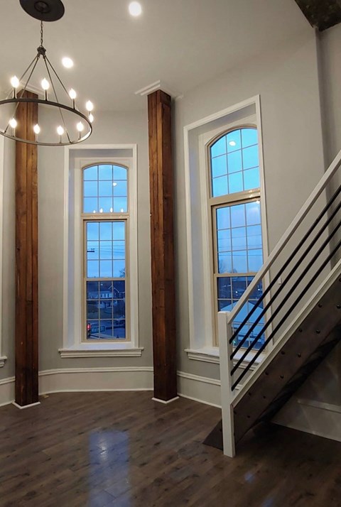 a living room with two windows and a staircase