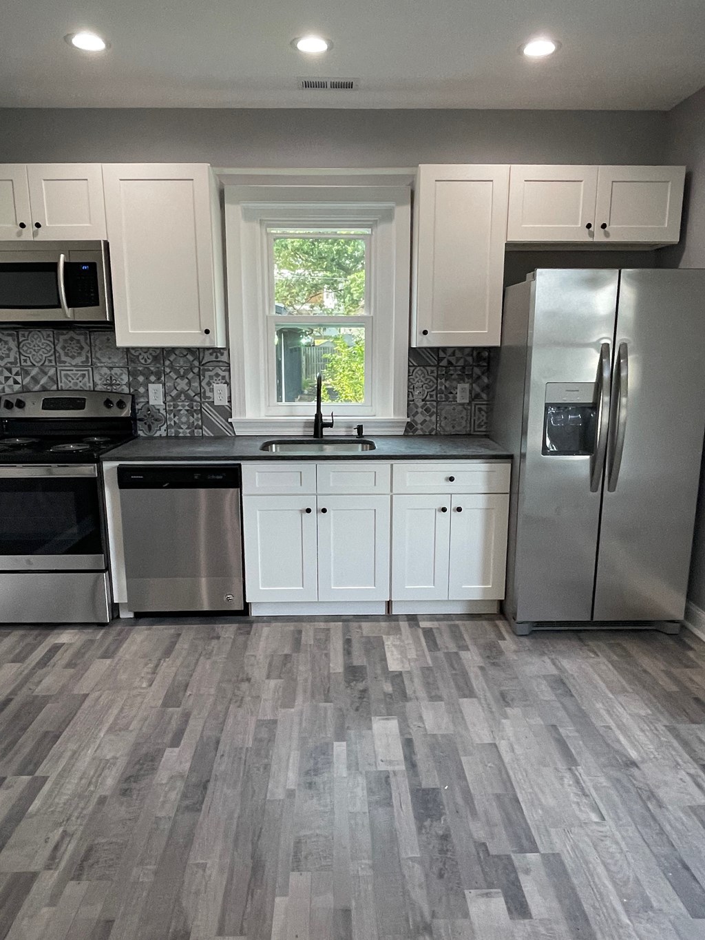 a kitchen with white cabinets and stainless steel appliances