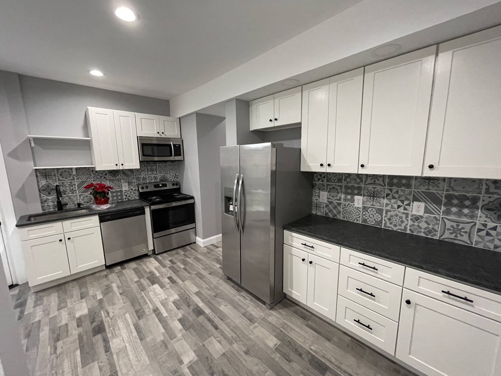 a kitchen with white cabinets and stainless steel appliances