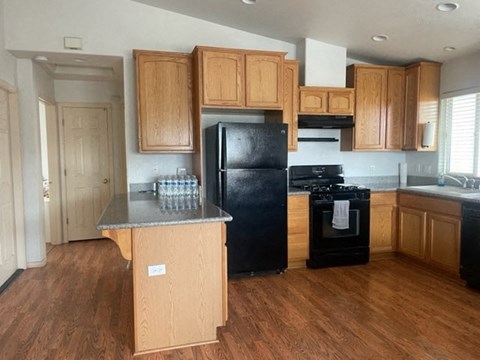 A kitchen with wooden cabinets and black appliances.
