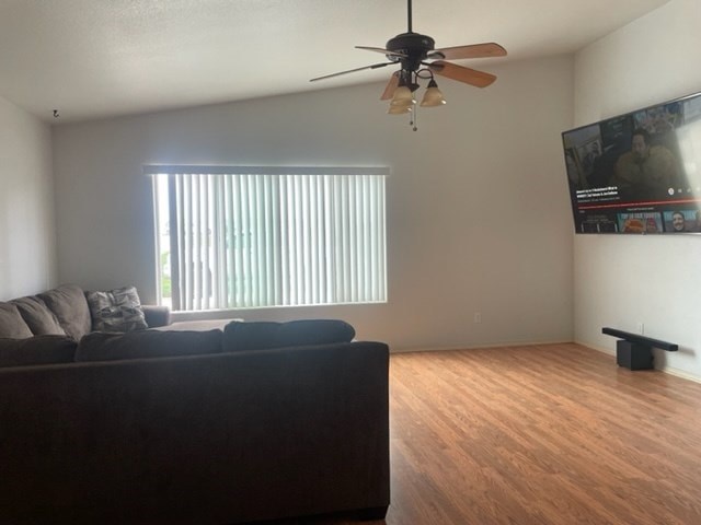 A living room with a couch and a ceiling fan.